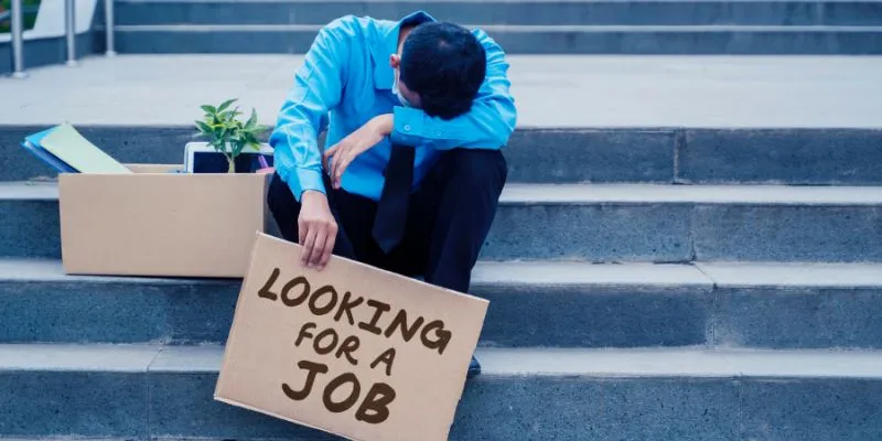 A stressed professional sitting at a desk, looking at a retrenchment letter, symbolizing the emotional impact of job loss and uncertainty in Singapore.